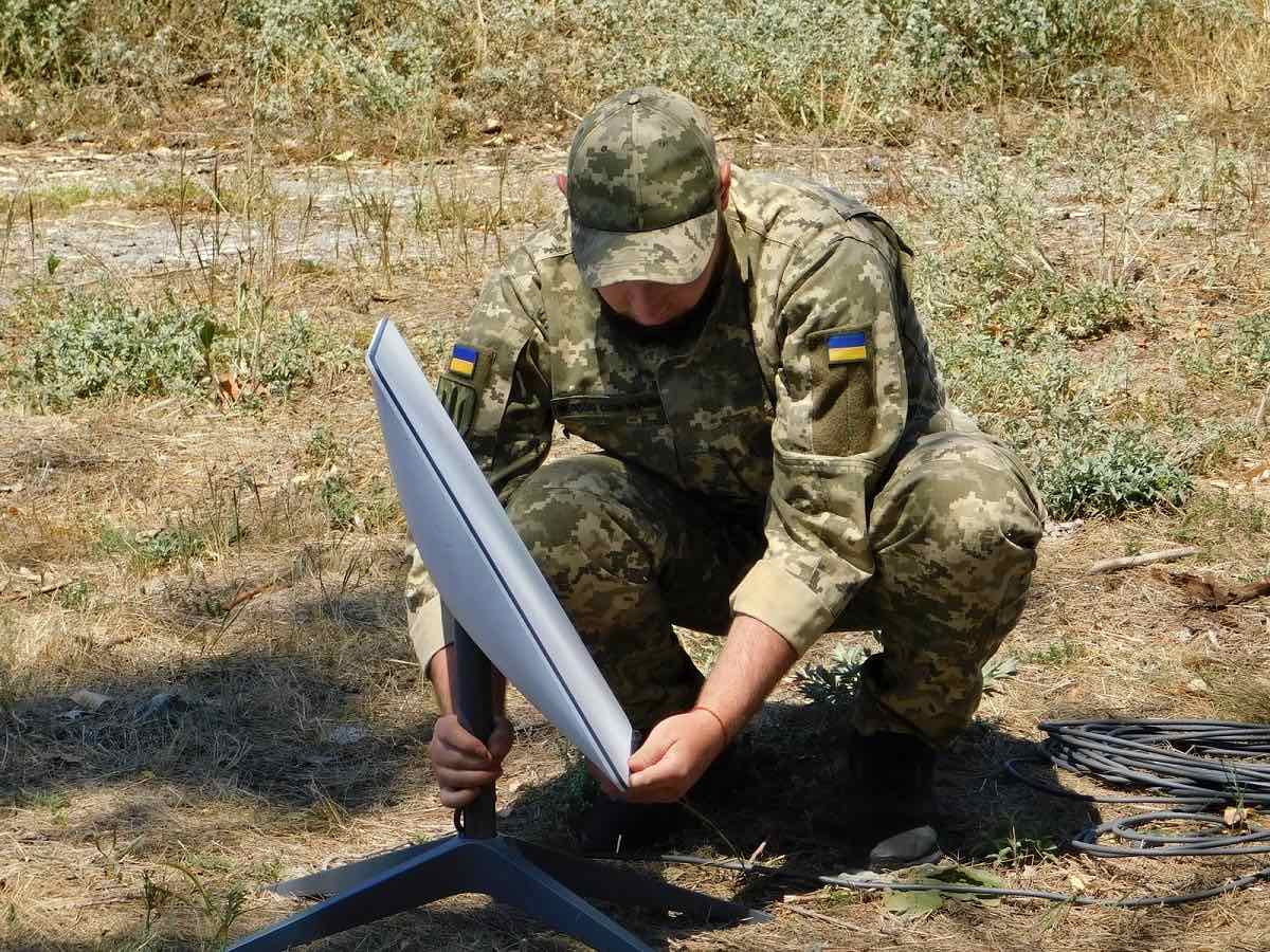 Militar din Forțele de Sprijin ale Ucrainei instalând un terminal Starlink